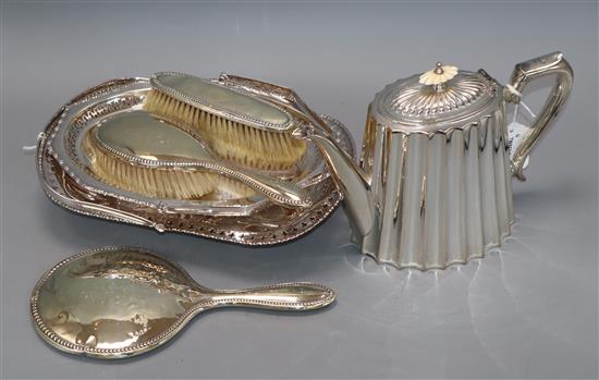 A silver-mounted four-piece dressing table set, a plated fluted teapot and two plated swing-handled baskets